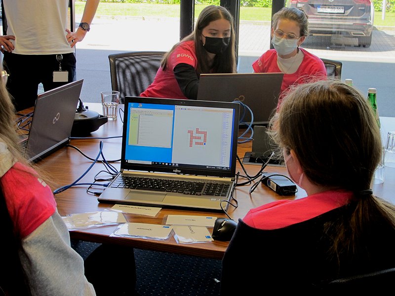 4 Teilnehmerinnen sitzen vor Laptops und lösen Programmieraufgaben.