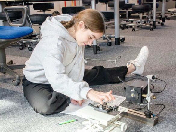 Ein Mädchen sitzt auf dem Boden und arbeitet am Morsegerät.