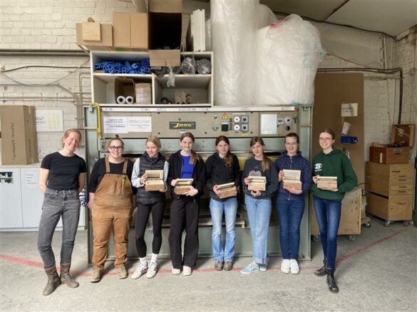 Gruppenbild: die beiden Ausbilderinnen der Tischlerei stehen links, die 6 teilnehmenden Mädchen rechts daneben.