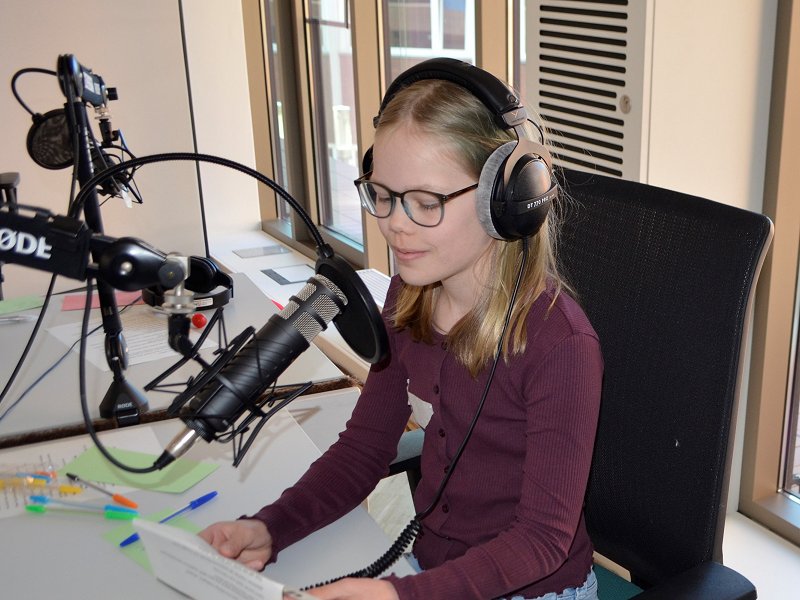 Eine Schülerin spricht allgemeine Infos zur Geschichte des Girls' Day als Meldung im Radio.