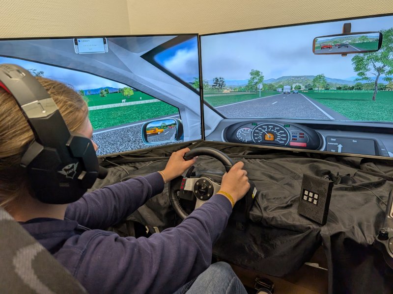 E-Sport in Praxis: Eine Schülerin fährt mit einem virtuellen Sportwagen ein Rennen.